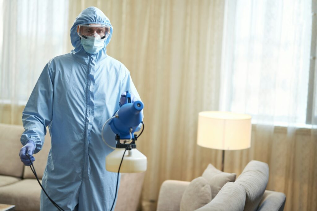 Worker making professional disinfecting in hotel room